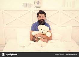 Cute and romantic. Bearded hipster play toy. Valentines day gift. Man hug  soft toy relaxing in bed. Make surprise concept. Gift for spouse. Cute teddy  bear toy. Softness tenderness. Playful adult Stock