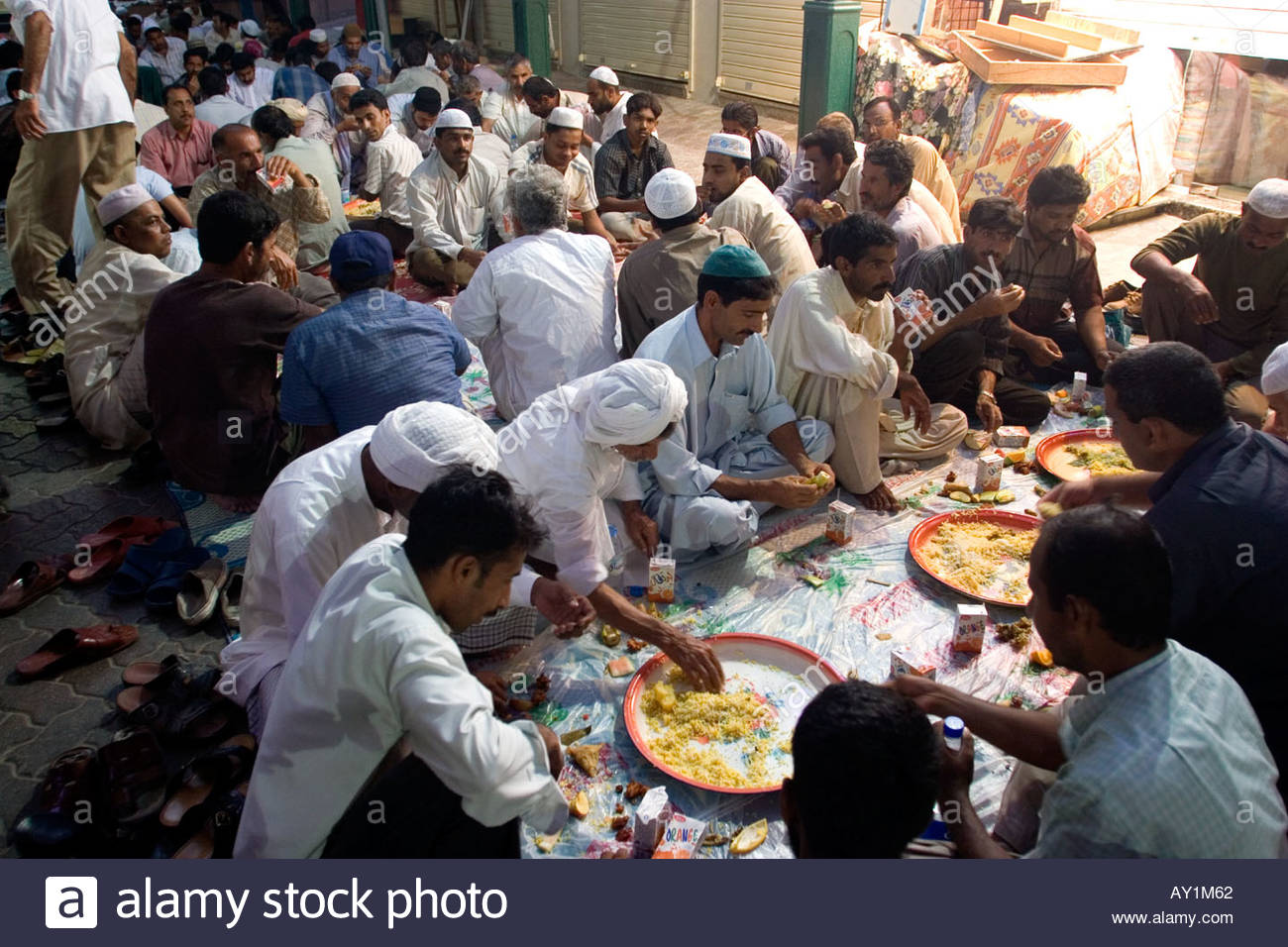 muslim-men-eats-together-outside-a-mosque-at-iftar-the-evening-meal-AY1M62.jpg
